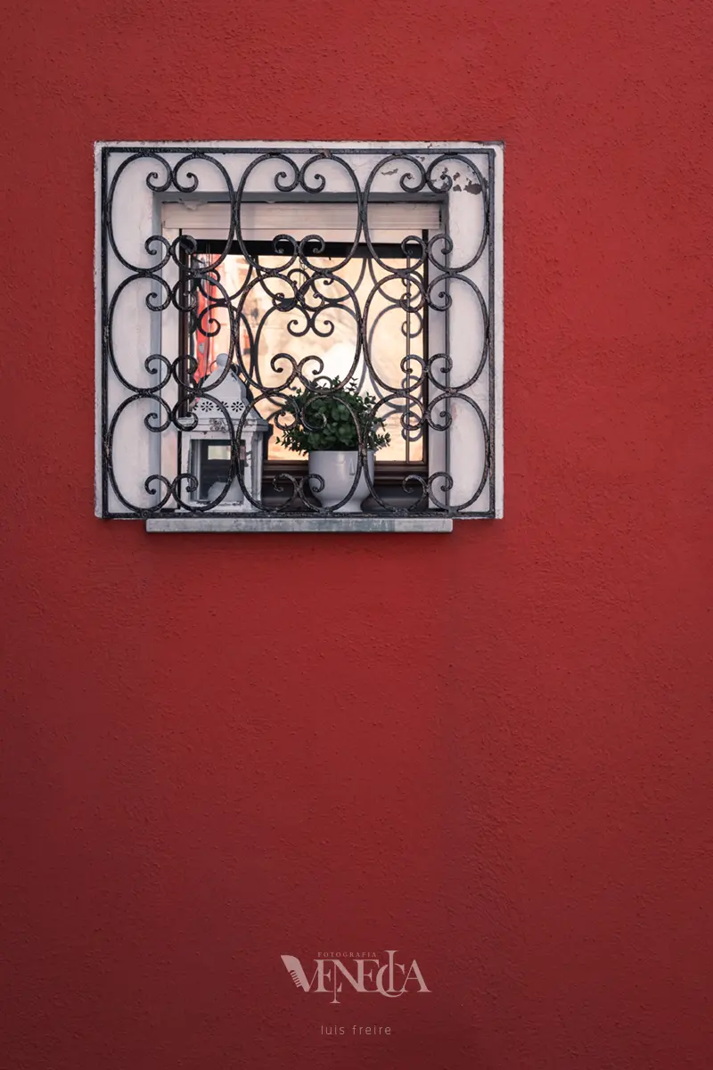 Ventana en pared de color rojo en Burano