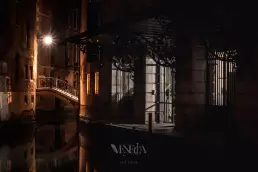 Canal y puente veneciano iluminado de noche