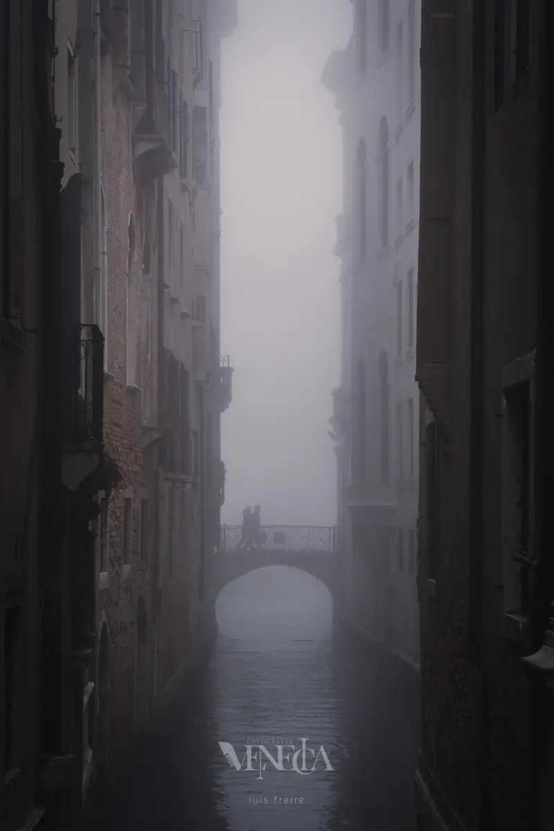 Personas cruzando un puente bajo la niebla en Venecia